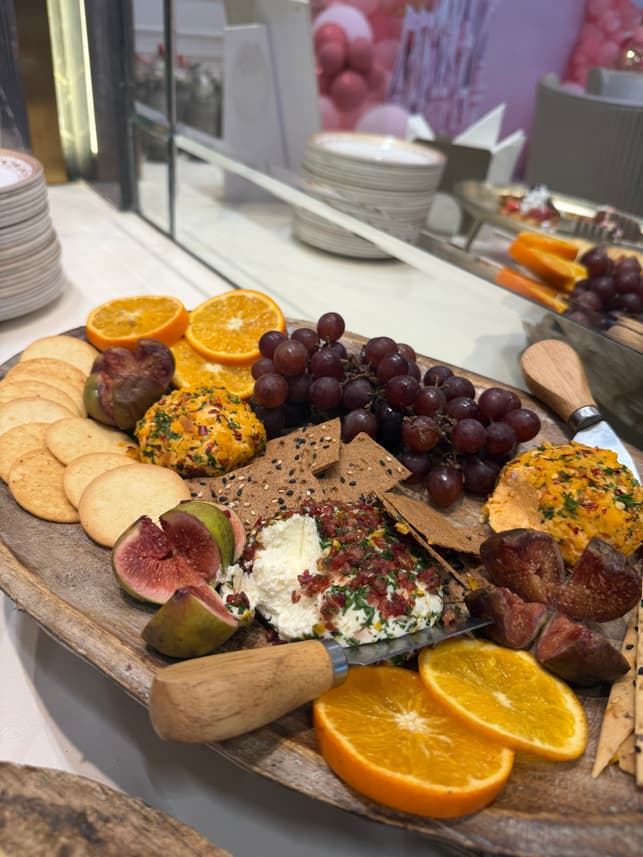 Artisanal cheese board with grapes, figs and citrus