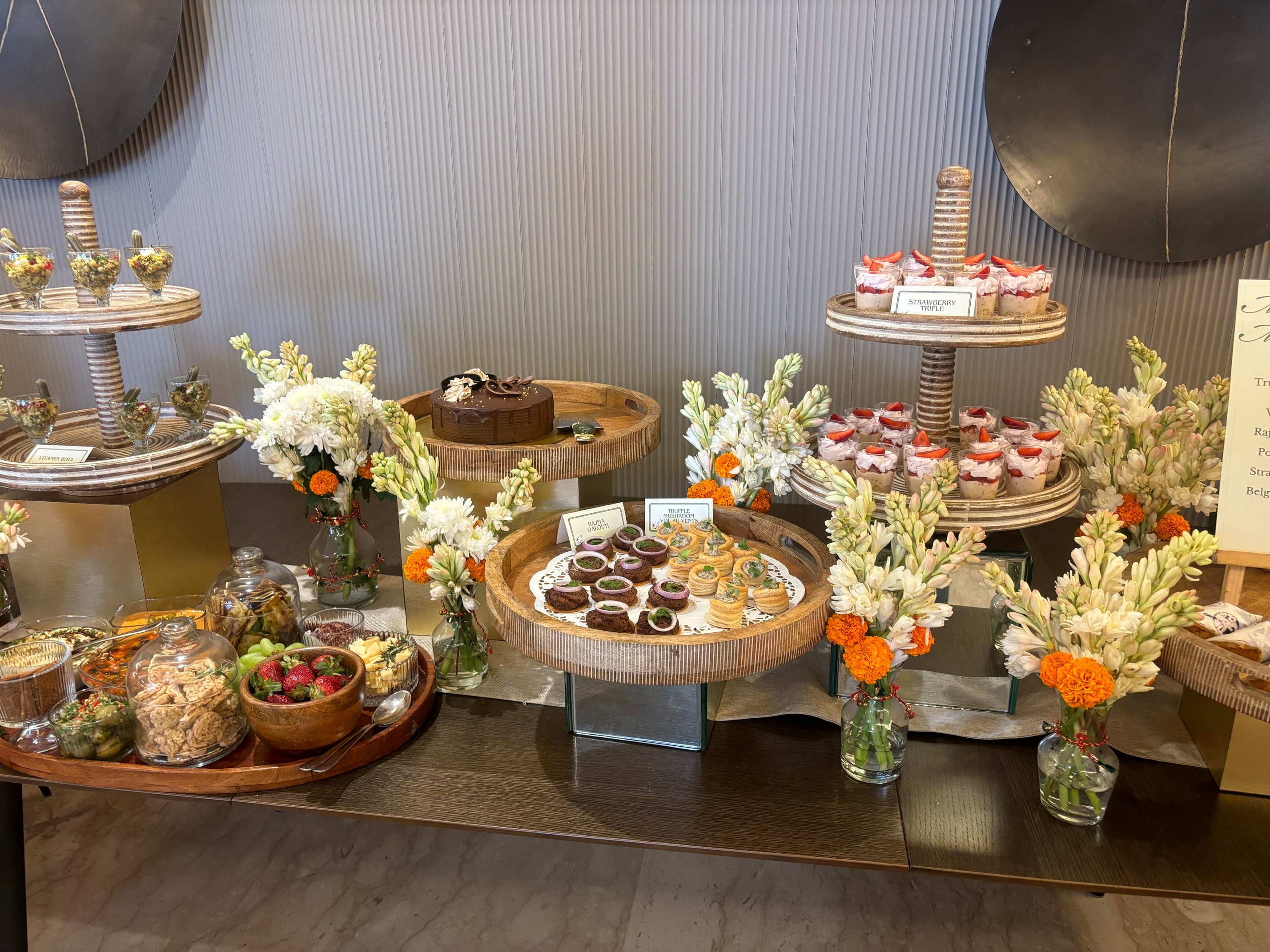 Hi-tea spread with chocolate cake, strawberry trifles, rajma galouti and truffle mushroom vol au vents